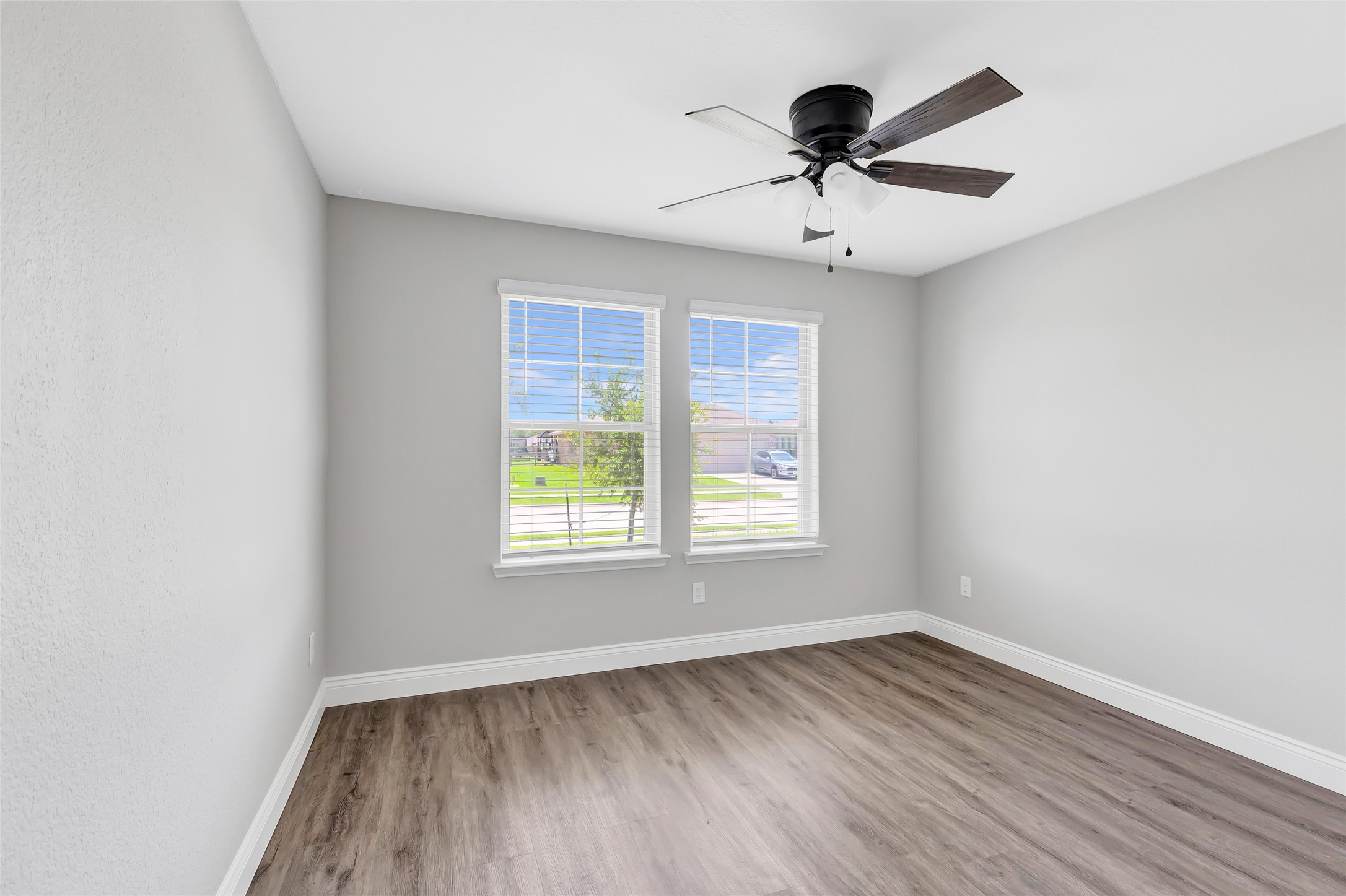 214 Kickapoo Drive Anahuac, TX 77514 - Photo 16 of 36 an empty room with wooden floor and windows