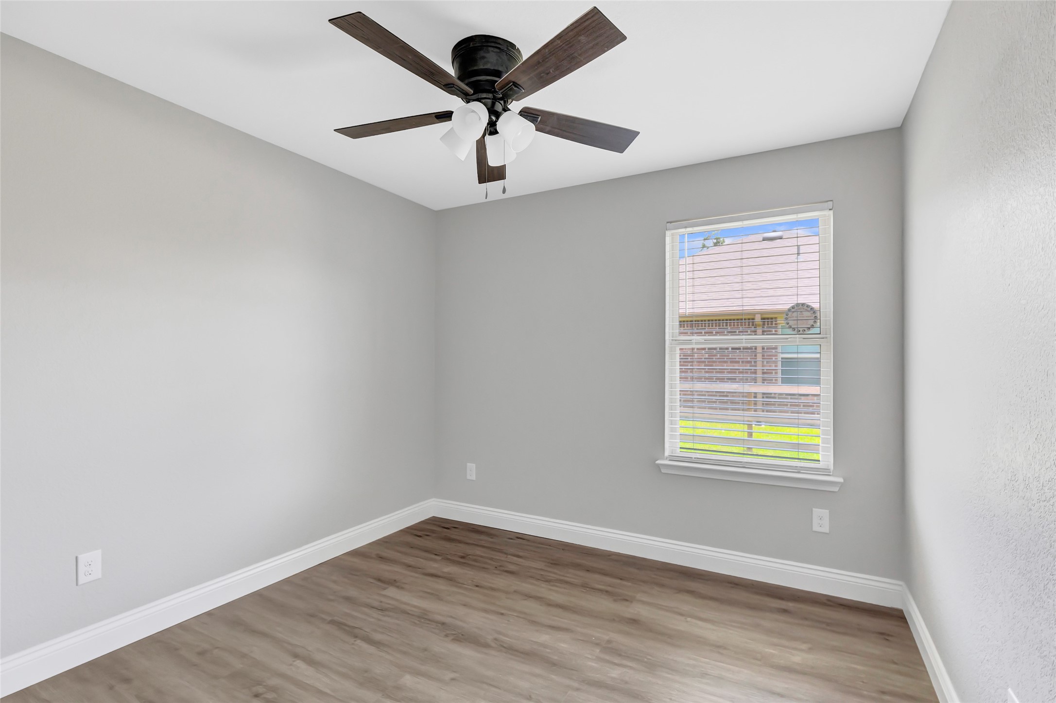214 Kickapoo Drive Anahuac, TX 77514 - Photo 21 of 36 an empty room with wooden floor ceiling fan and windows