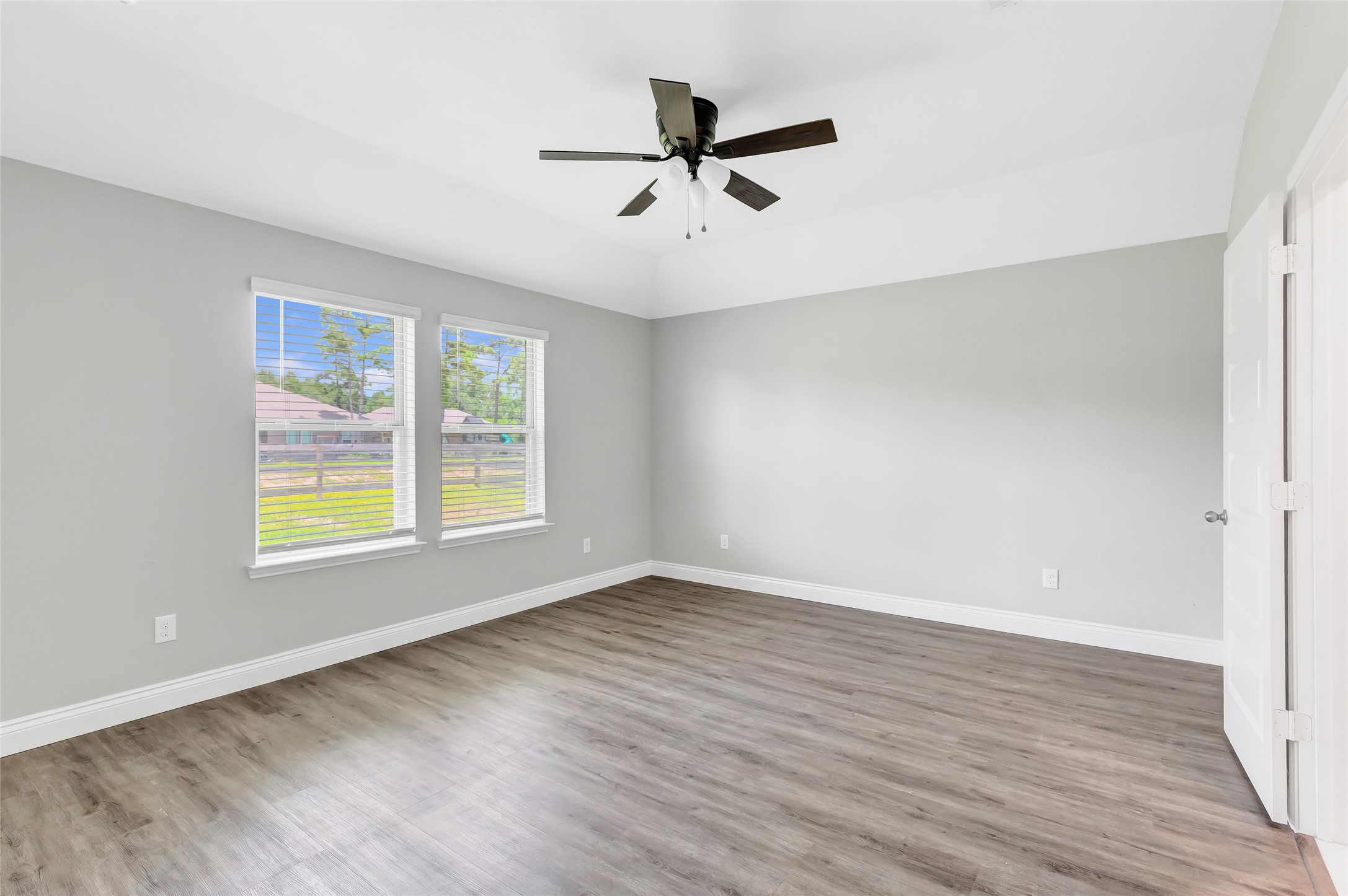214 Kickapoo Drive Anahuac, TX 77514 - Photo 23 of 36 an empty room with wooden floor chandelier fan and windows