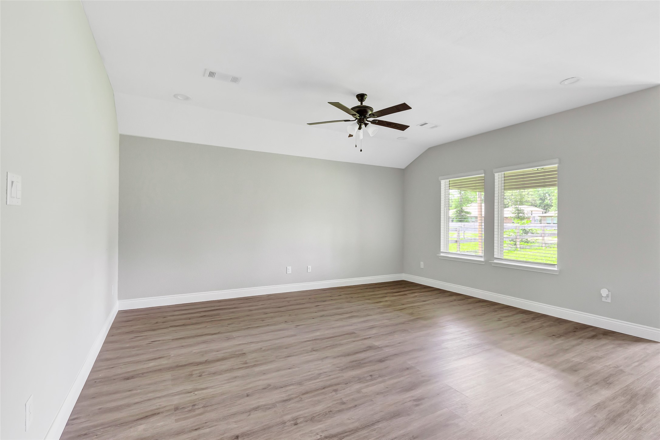 214 Kickapoo Drive Anahuac, TX 77514 - Photo 7 of 36 an empty room with wooden floor and windows