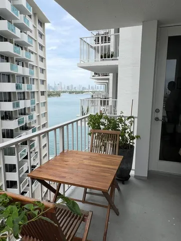 a view of a balcony dining table and chairs with potted plants