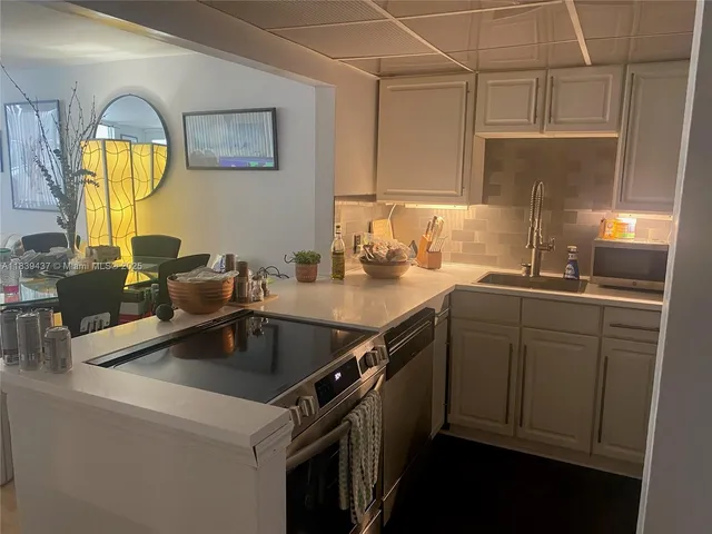 a kitchen with a sink appliances and cabinets