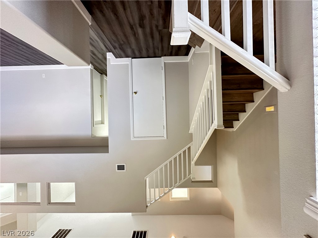 10191 Splendor Ridge Avenue Las Vegas, NV 89135 - Photo 14 of 31 Elegant wooden staircase with crisp white railings provides a striking focal point.