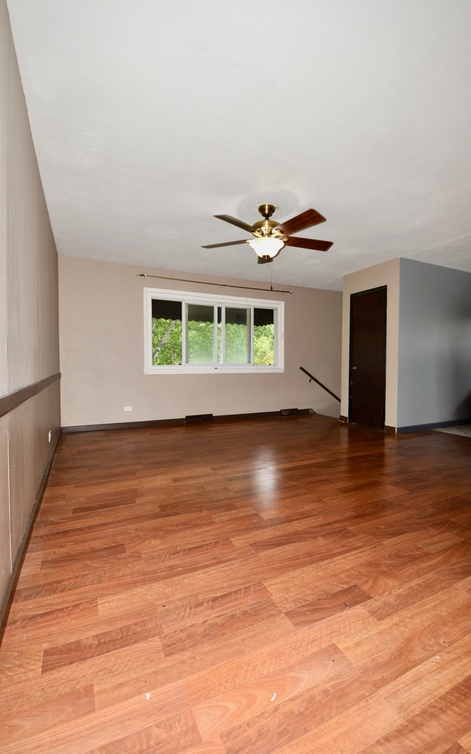 13 Tweed Road Fox Lake, IL 60020 - Photo 3 of 23 a view of an empty room with wooden floor and a window