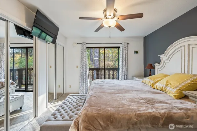 a spacious bedroom with a bed and a flat screen tv