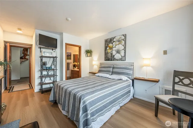 a bedroom with a bed and wooden floor