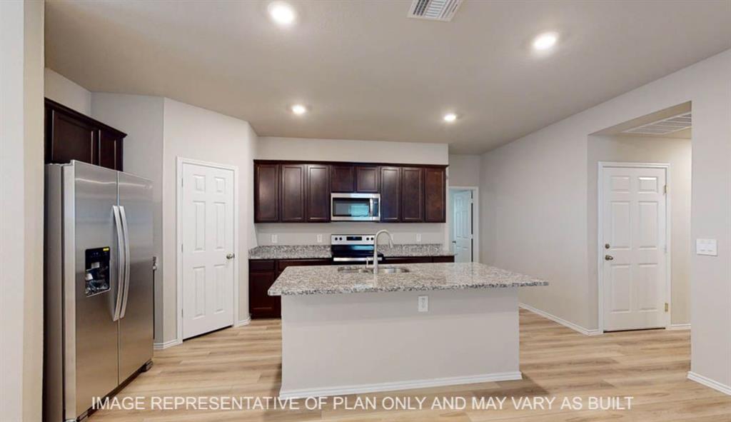3112 Cyprian Road Lorena, TX 76655 - Photo 3 of 20 Modern kitchen featuring dark cabinetry, stainless steel appliances including a side-by-side refrigerator and microwave, granite-look countertops, and a white island with breakfast bar seating