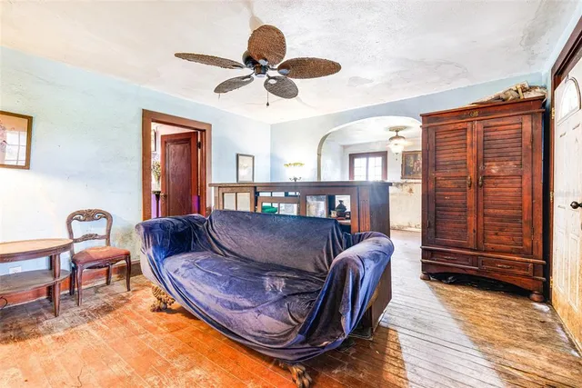 a living room with furniture a ceiling fan a rug and a window