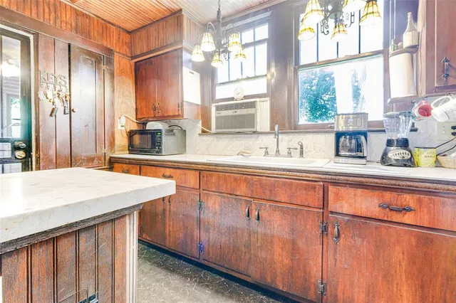 a kitchen with stainless steel appliances granite countertop a sink a stove cabinets and a large window