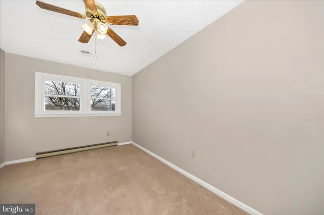 an empty room with a window and a fan
