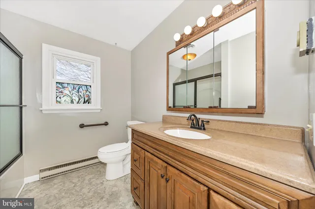 a bathroom with a granite countertop sink mirror and a toilet
