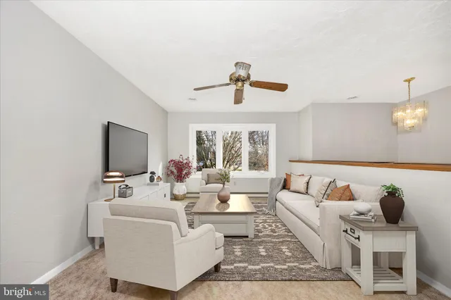 a living room with furniture a chandelier and a flat screen tv