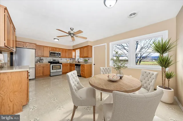 a kitchen with stainless steel appliances a table and chairs