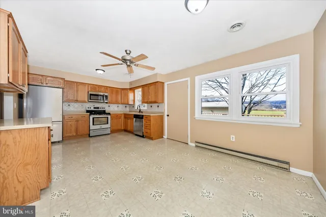 a view of kitchen with stove and refrigerator