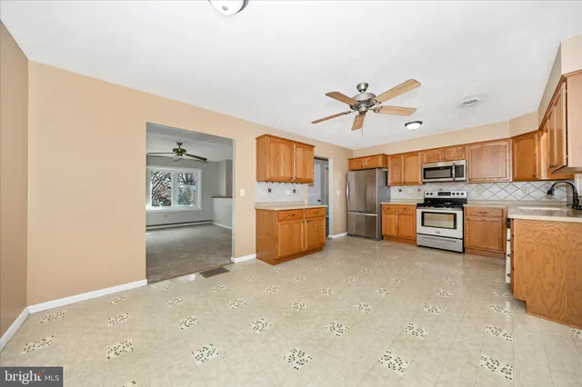a kitchen with stainless steel appliances a stove top oven a sink and a refrigerator