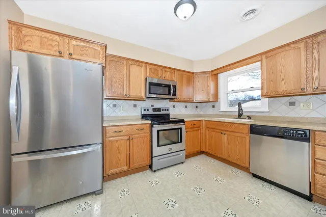 a kitchen with stainless steel appliances granite countertop a refrigerator stove a sink dishwasher and microwave