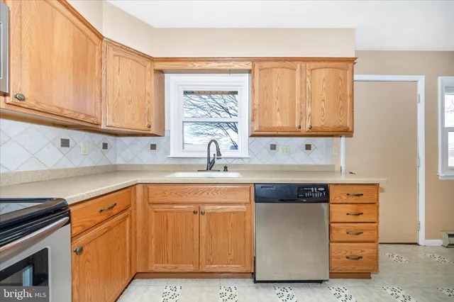 a kitchen with cabinets appliances a sink and a window