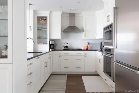 a kitchen with stainless steel appliances white cabinets and a sink