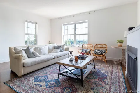a living room with furniture a flat screen tv and a window