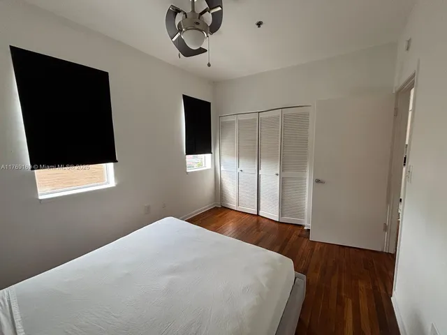 a bedroom with a bed and a flat tv screen on a dresser