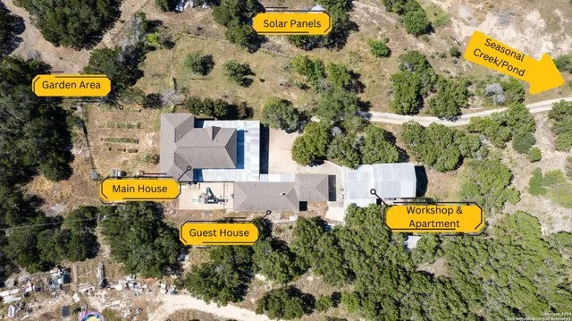 an aerial view of a house with a swimming pool a yard and a fountain