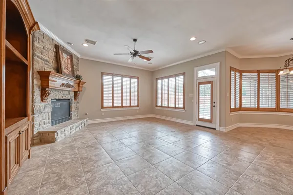 a view of an empty room with a fireplace and a window