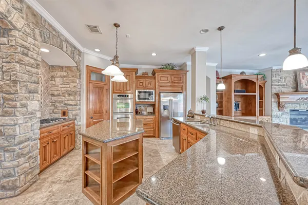 a kitchen with stainless steel appliances granite countertop a stove a sink and a refrigerator