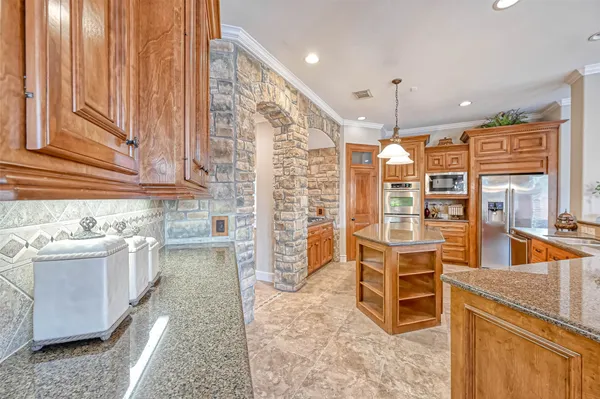 a kitchen with stainless steel appliances granite countertop a sink and a refrigerator
