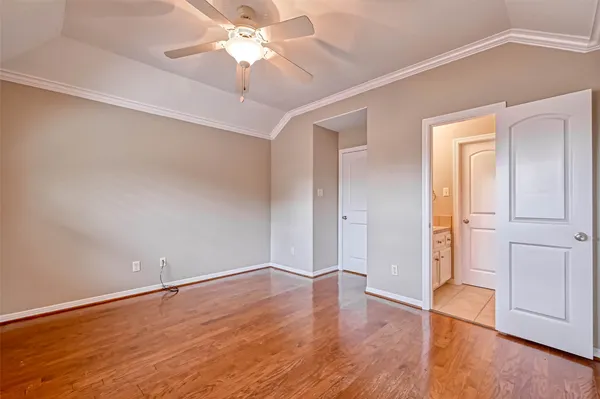 an empty room with wooden floor and ceiling fan