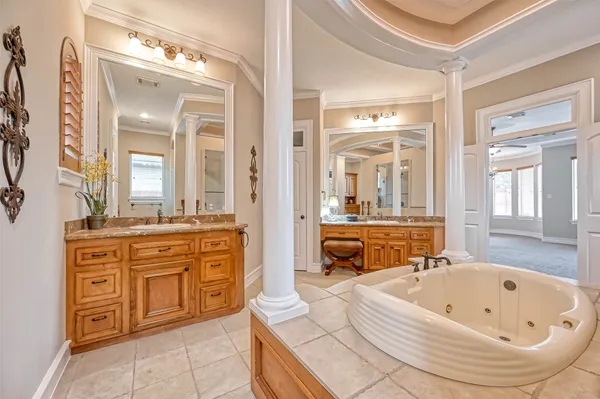 a bathroom with a tub a double vanity sink and a large mirror