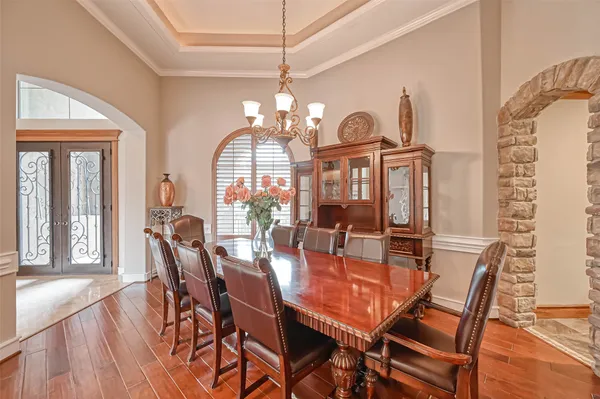 a view of a dining room with furniture a chandelier and wooden floor