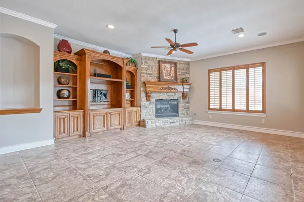 a view of an empty room with a fireplace and a window