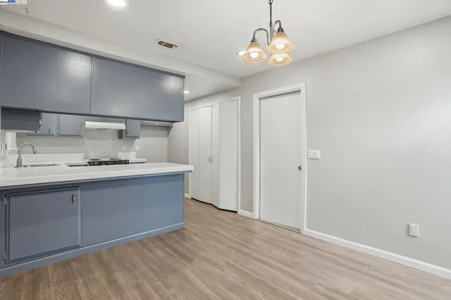 a kitchen with granite countertop a sink cabinets and wooden floor