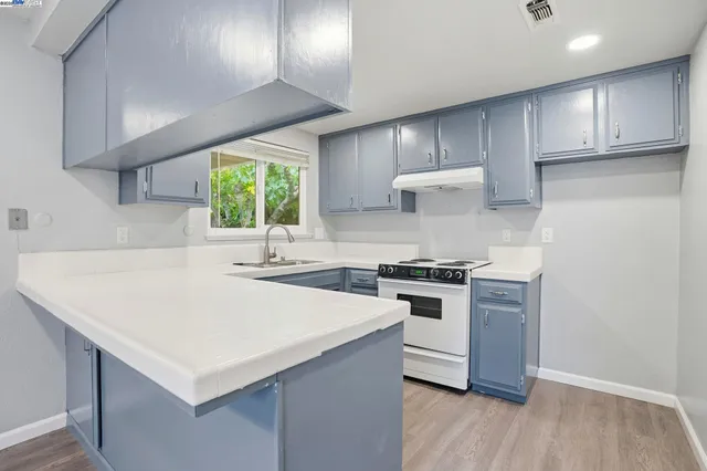 a kitchen with a stove a sink and a refrigerator