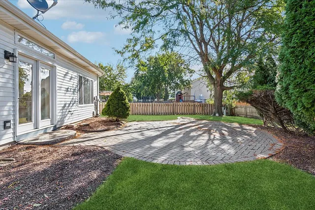 a view of a house with backyard and a tree