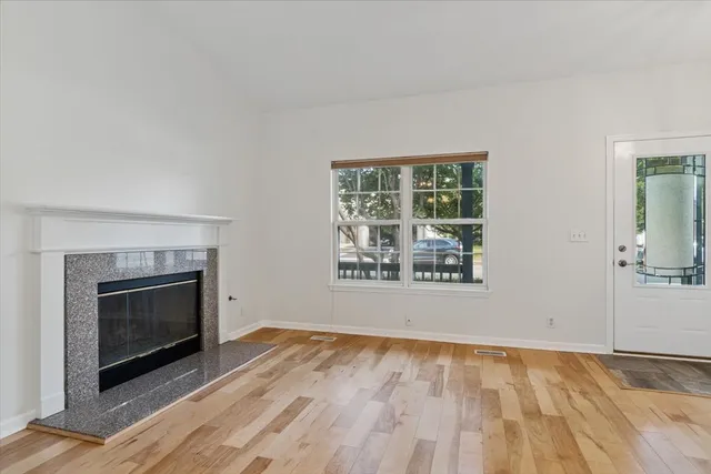 an empty room with windows and fireplace
