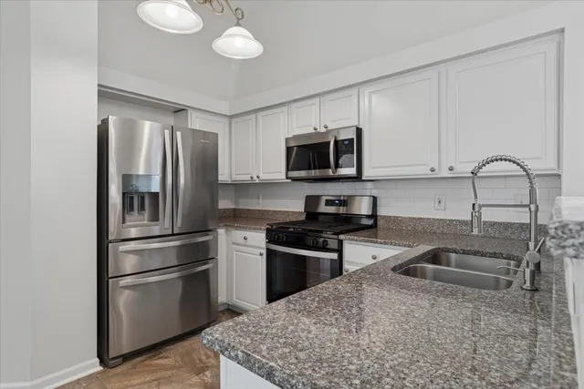 a kitchen with stainless steel appliances granite countertop a refrigerator stove top oven a sink and dishwasher