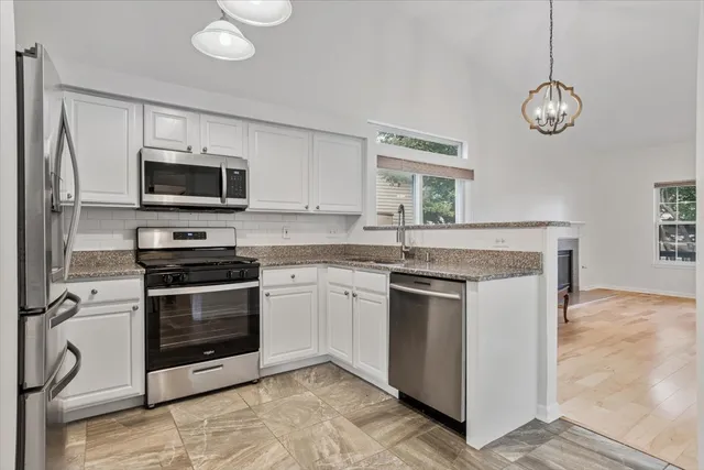 a kitchen with stainless steel appliances granite countertop a stove and a microwave