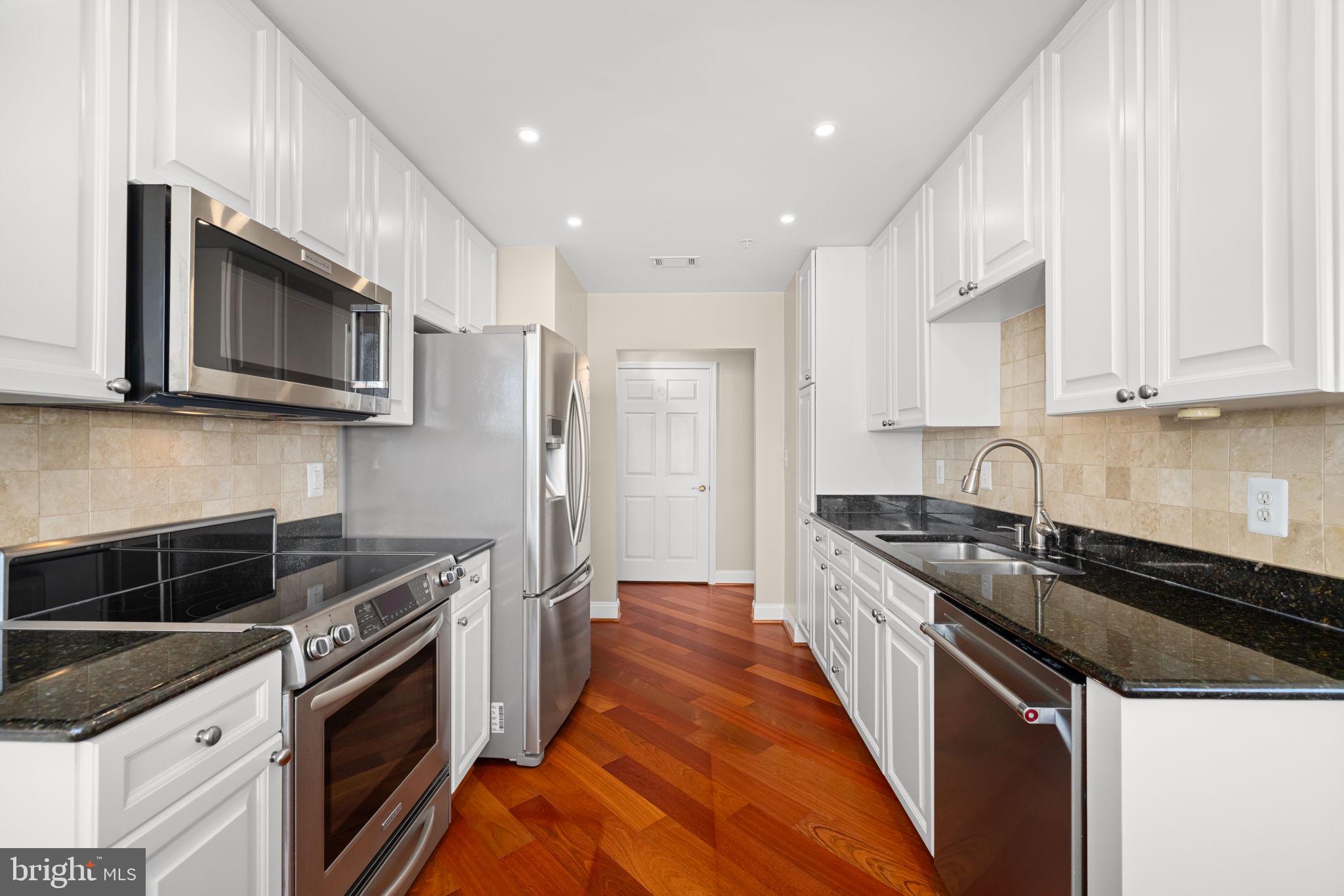 11776 Stratford House Place, Unit 907 Reston, VA 20190 - Photo 13 of 38 a kitchen with stainless steel appliances granite countertop a stove a sink and a microwave