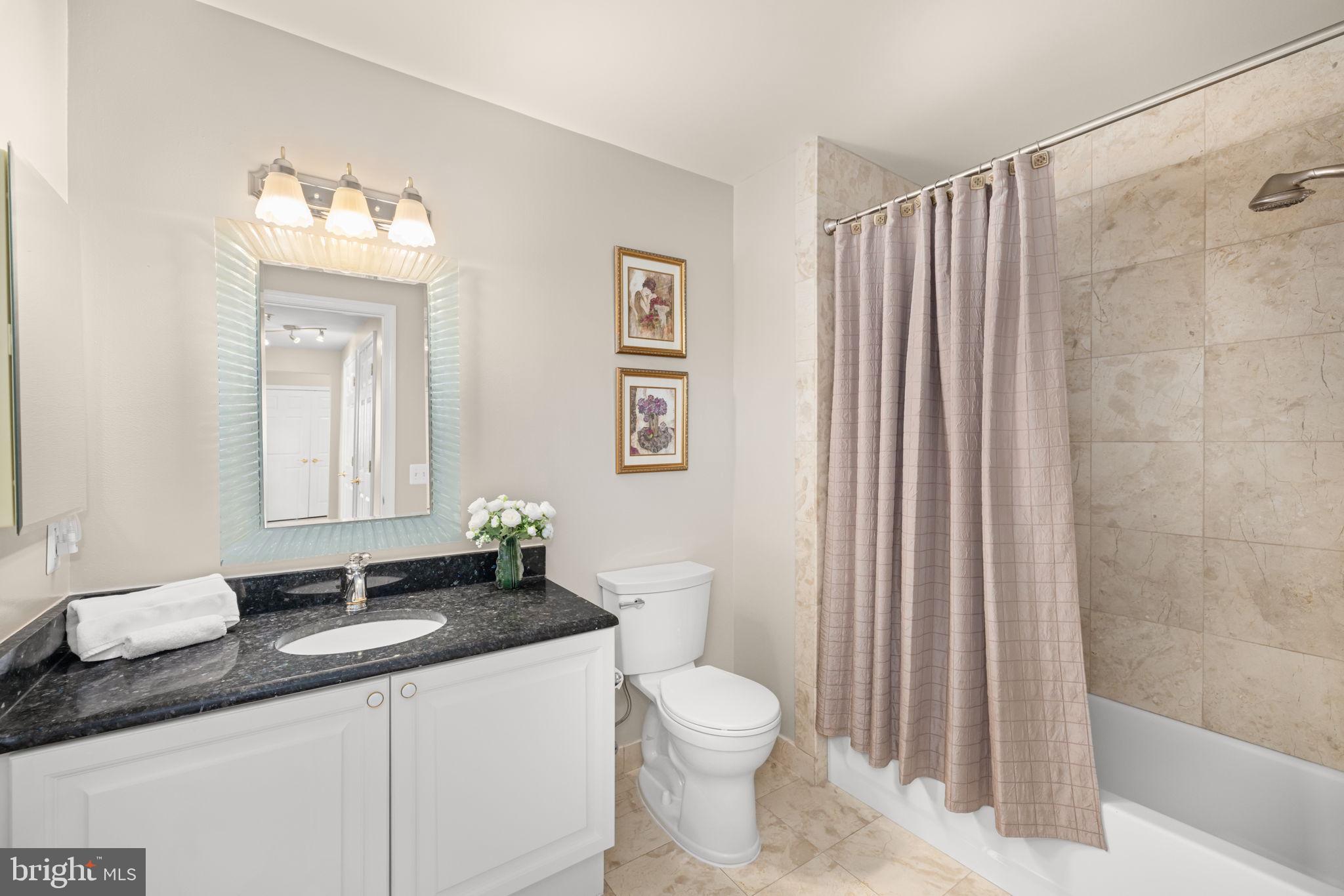 11776 Stratford House Place, Unit 907 Reston, VA 20190 - Photo 25 of 38 a bathroom with a granite countertop sink mirror vanity and toilet