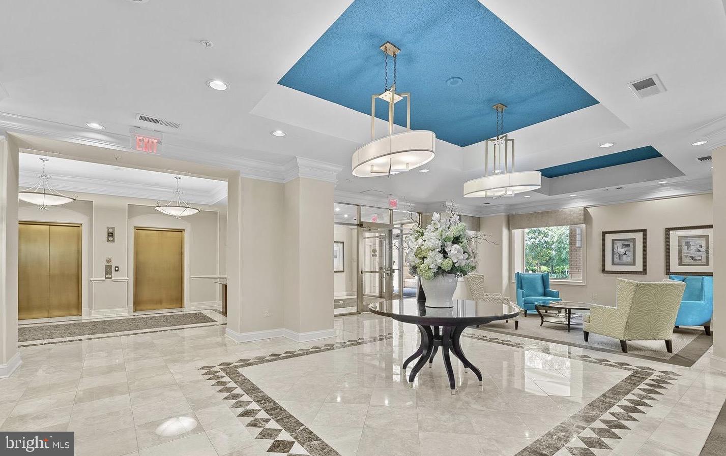 11776 Stratford House Place, Unit 907 Reston, VA 20190 - Photo 30 of 38 a view of a dining room and livingroom with furniture wooden floor a rug a painting and a chandelier