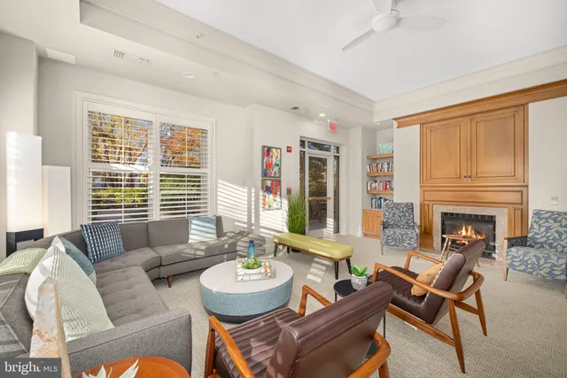 a living room with fireplace furniture and a large window