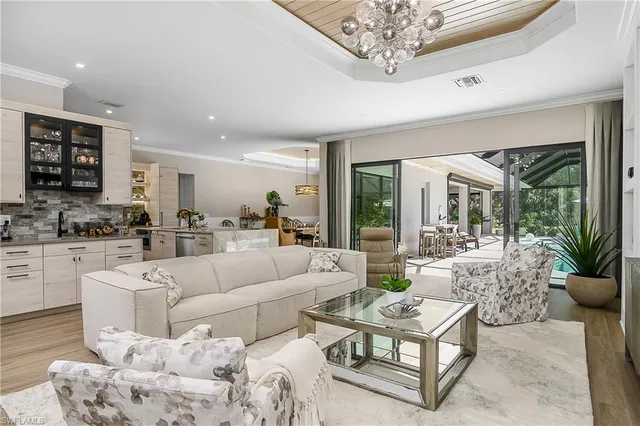 a living room with furniture a chandelier and a large window
