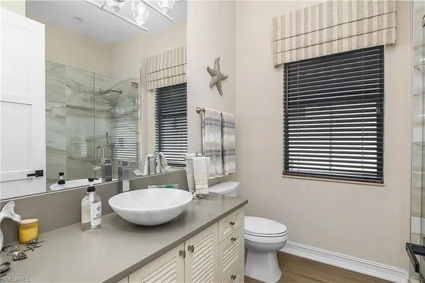 a bathroom with a toilet a sink and mirror