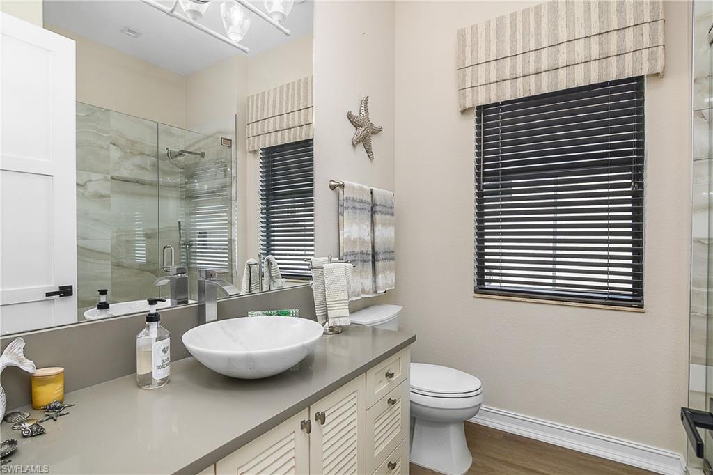 9489 Italia Way Naples, FL 34113 - Photo 20 of 50 a bathroom with a toilet a sink and mirror