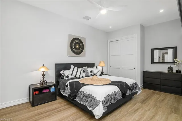 a bedroom with a bed and a lamp on dresser