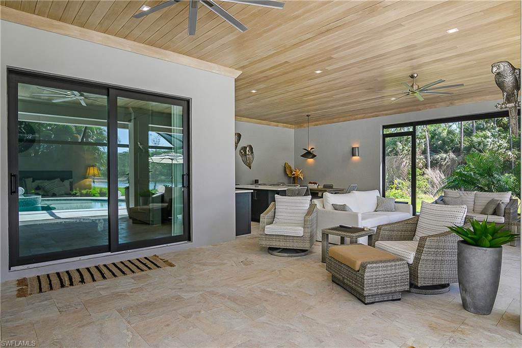 9489 Italia Way Naples, FL 34113 - Photo 30 of 50 a outdoor space with patio the couches and a dining table with garden view