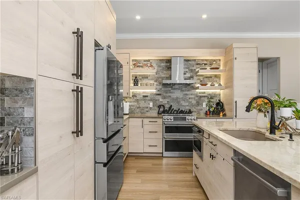 a kitchen with stainless steel appliances granite countertop a sink and a refrigerator