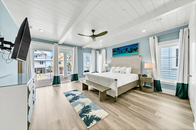 a spacious bedroom with a bed a flat screen tv and a large window