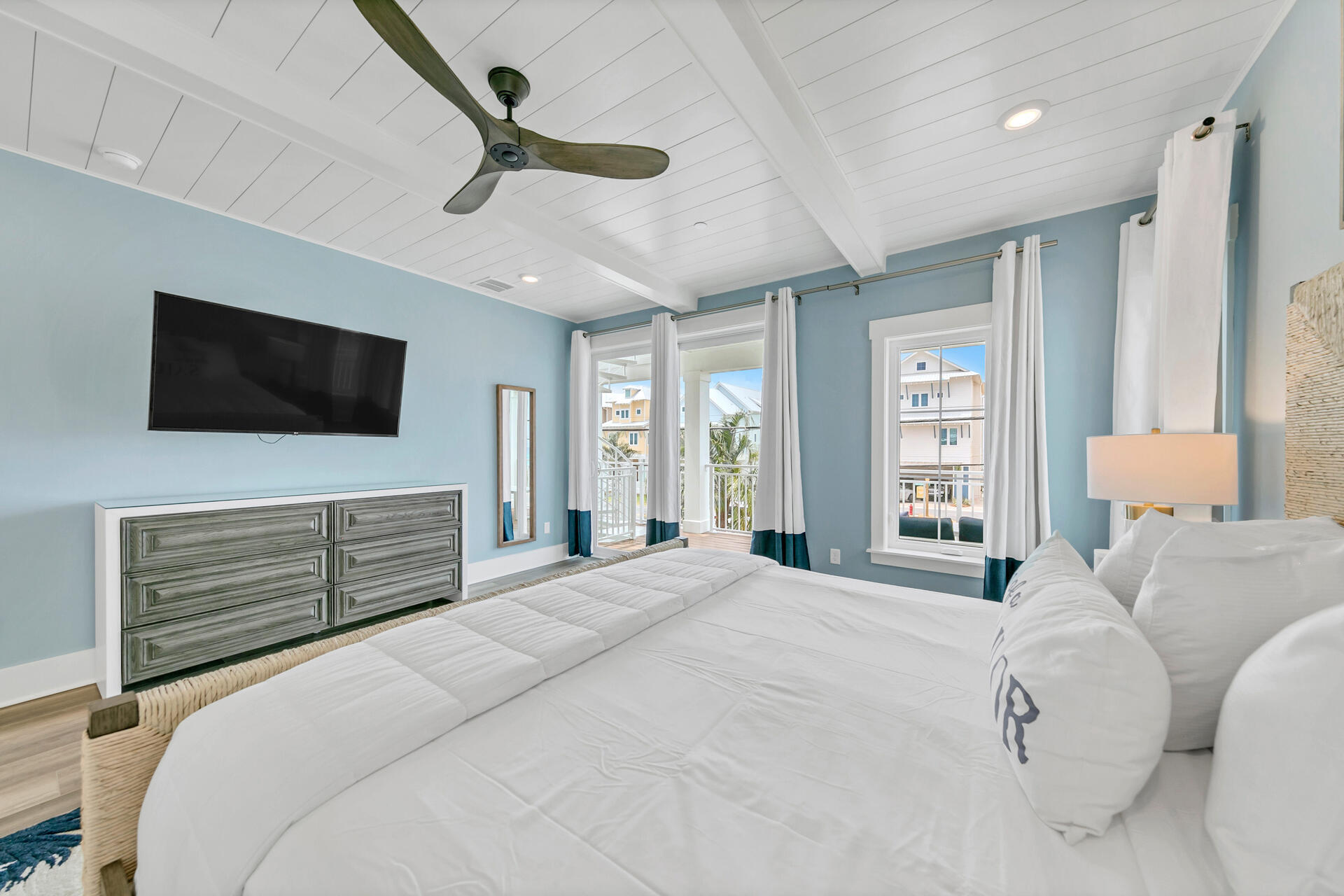 13662 Front Beach Road Panama City Beach, FL 32413 - Photo 21 of 46 a bedroom with a bed a tv and wooden floor